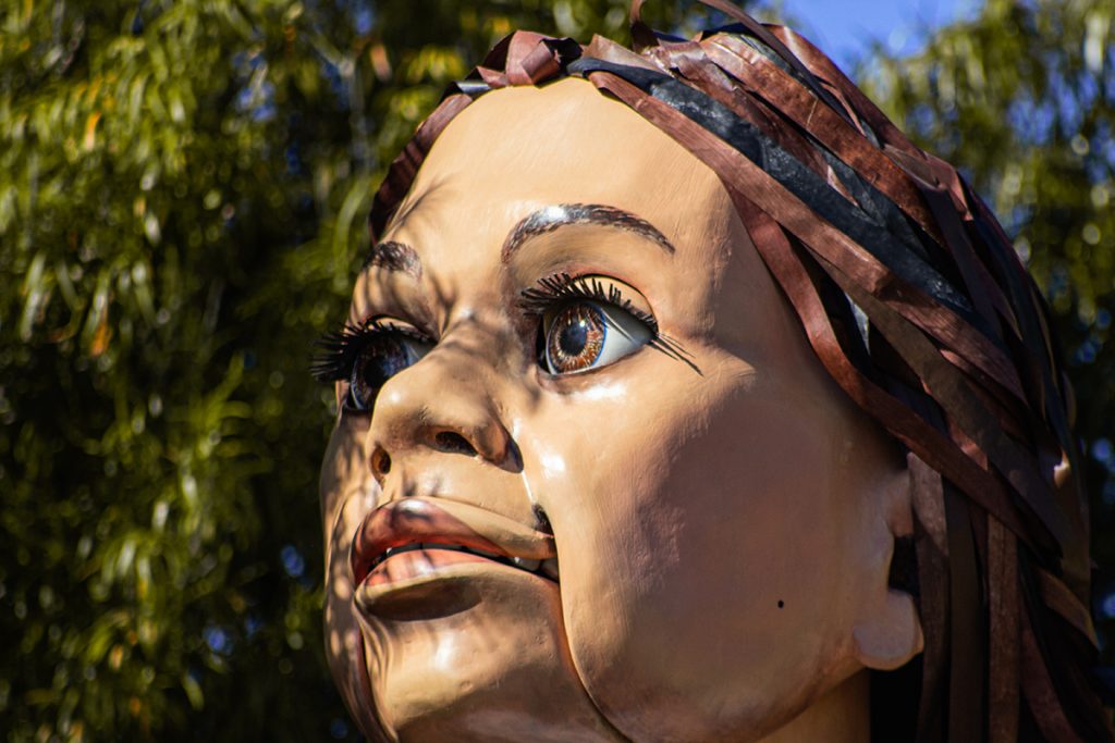 Close up image of a face. The face belongs to teh puppet Little Amal